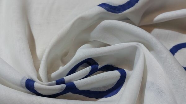 Ecru voile stof met blauwe bloemen close-up	