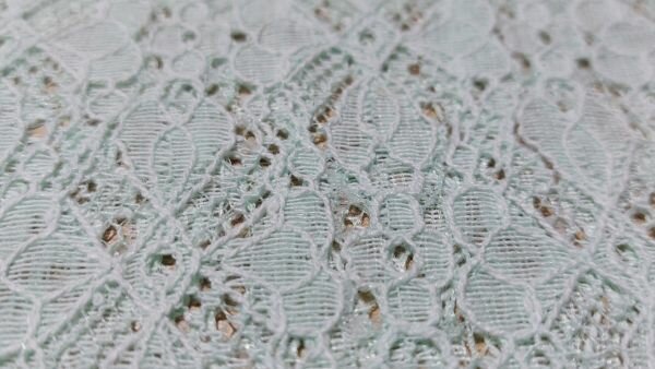 Detail kant met bloemen in mintgroen