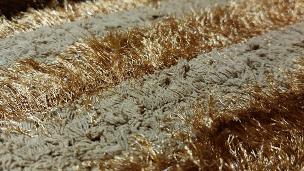 teddyachtige stof oker met glitterstrepen	