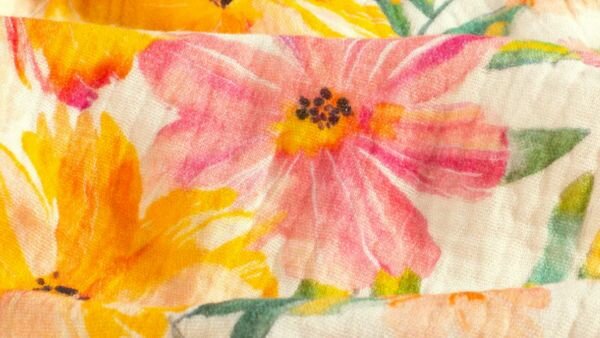 Detail van katoenen mousseline stof met bloemenprint