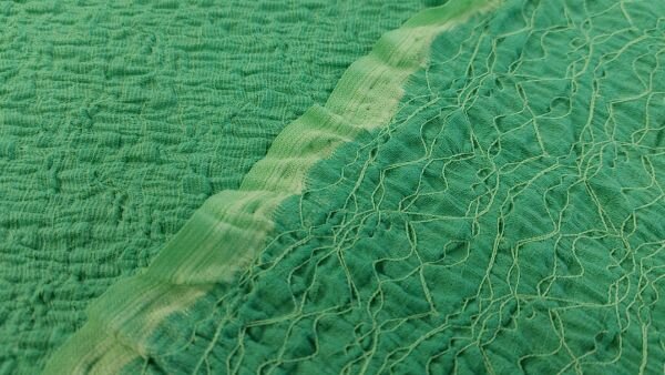 smogged embroidery groene stof close-up