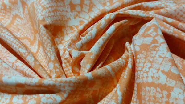 Katoenen couponstof oranje wit slangenprint lichtgewicht