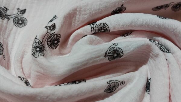 Lichtroze mousseline stof met zwarte fietsen print