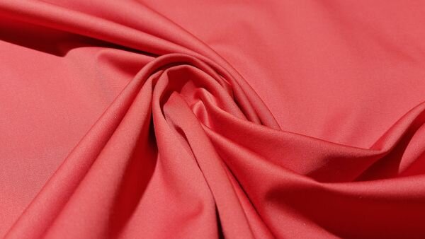 Detail van satijnbinding in oranje broekenstof	